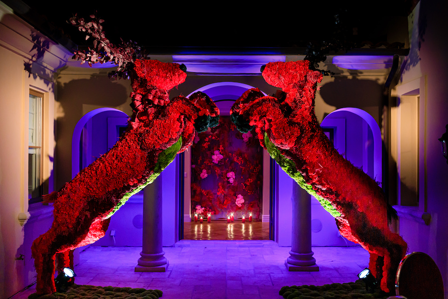 two large red reindeer topiary in entryway of holiday party